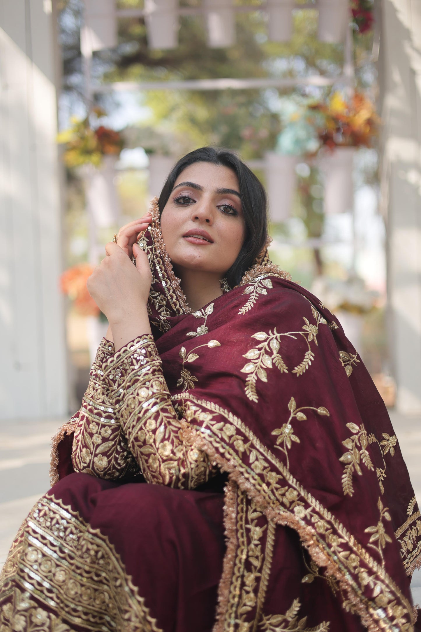Elegant maroon designer gown for women with intricate gold embroidery and a stylish silhouette