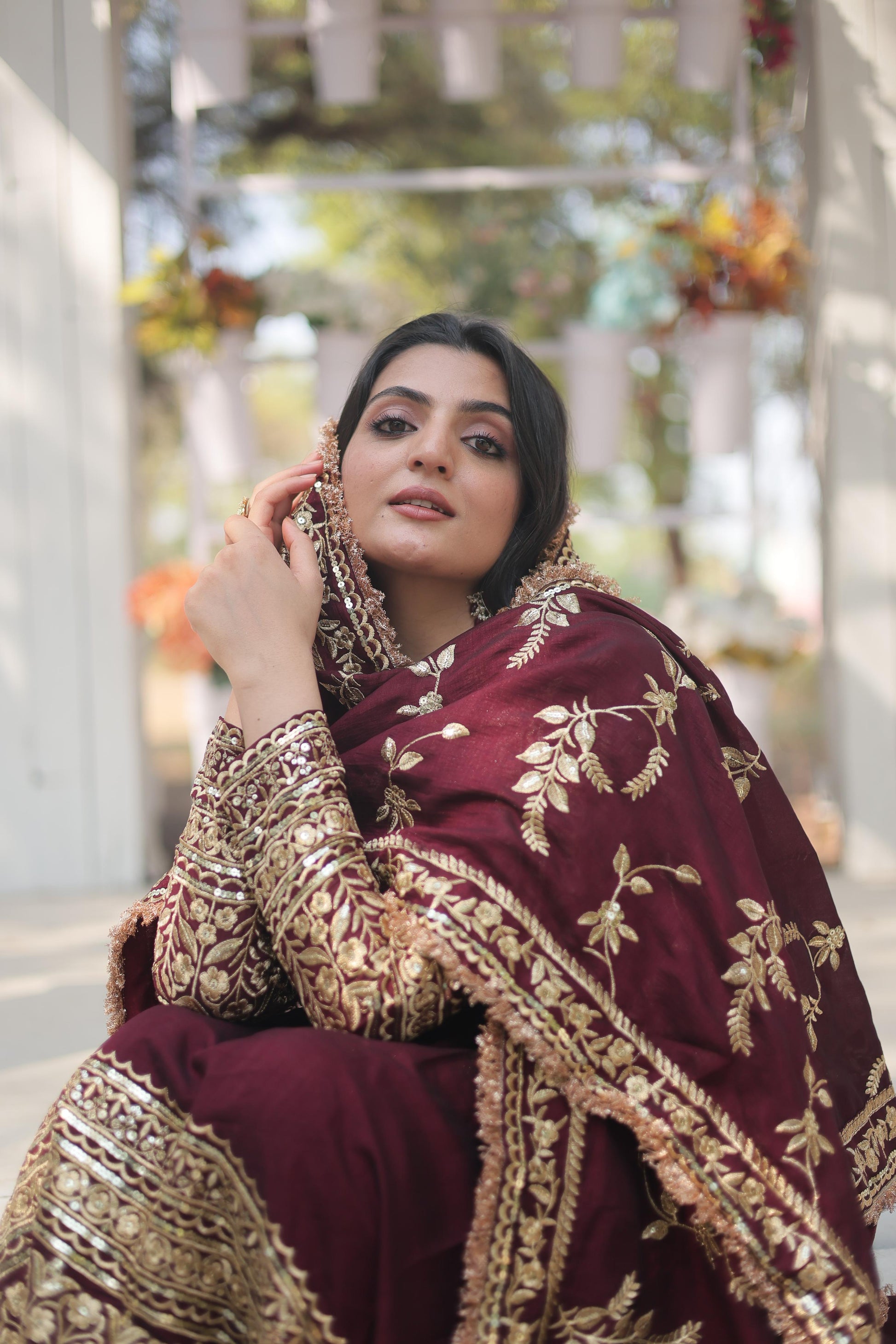 Elegant maroon designer gown for women with intricate gold embroidery and a stylish silhouette