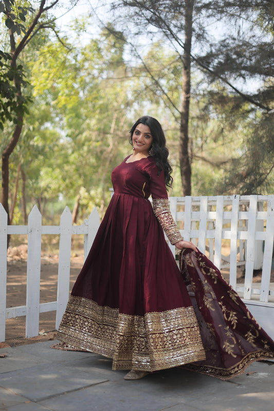 Elegant designer gown for women featuring a deep burgundy color and intricate gold embroidery